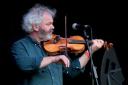 Graham Vincent on stage with one of his handmade violins.