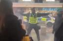 A police officer struggles to maintain order in Sauchiehall Street on Sunday as shoppers caught up