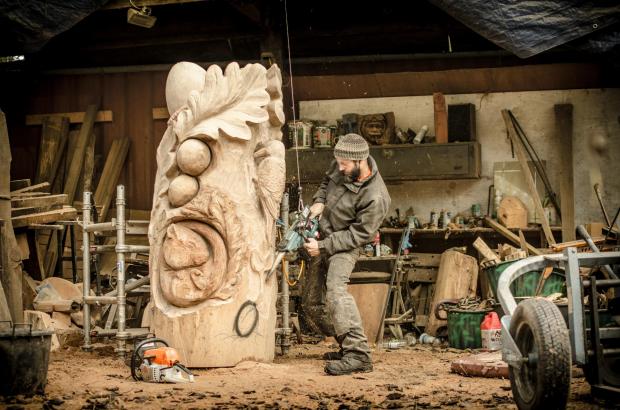 Forestry Journal: Dan carving the ‘Oak in the wood’ sculpture in his workshop using the weight-compensating device.