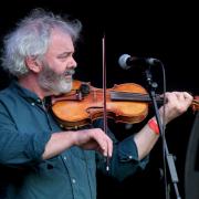 Graham Vincent on stage with one of his handmade violins.